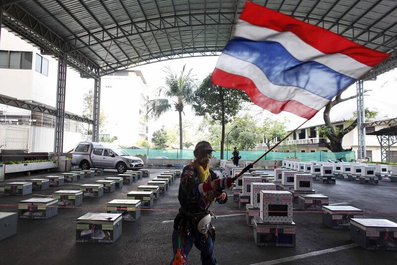 An anti-government protester waves inside a district office next to election boxes which are to be delivered to polling stations, just before the beginning of voting in Bangkok. Nir Elias