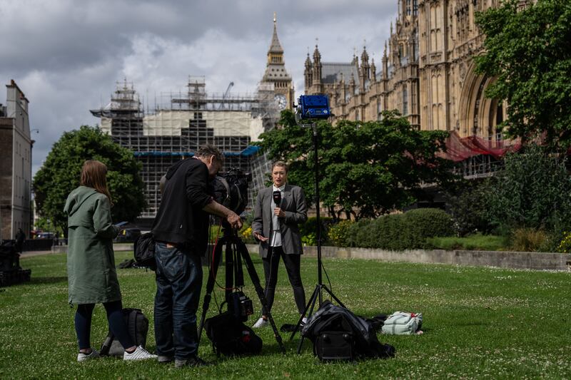 A broadcast journalist at work on College Green outside the Houses of Parliament in London. Getty Images