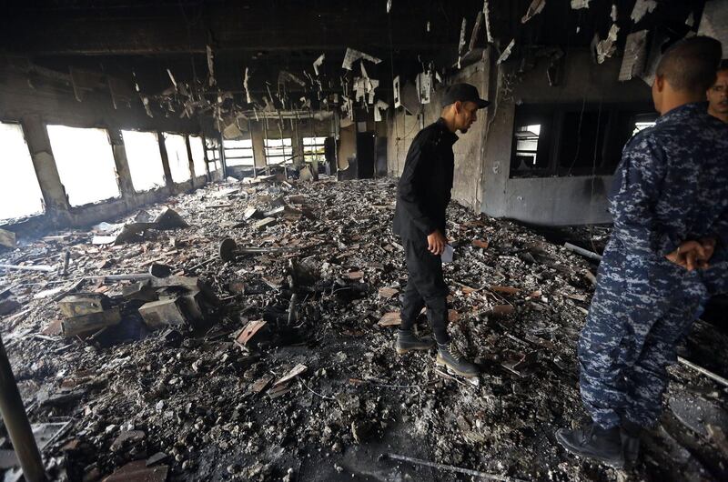 Libyan police check the damage at the Libyan electoral commission headquarters in the capital Tripoli after it was targeted by suicide bombers on May 2, 2018.
Suicide bombers stormed Libya's electoral commission in the Libyan capital, killing at least a dozen people in an attack claimed by the Islamic State jihadist group. / AFP PHOTO / MAHMUD TURKIA