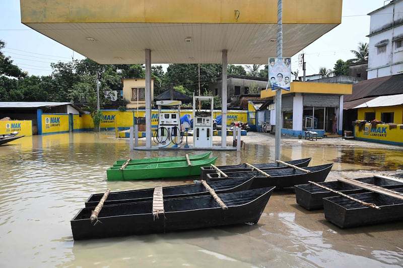 Makeshift boats are seen parked next to a petrol pump following heavy rain in Ghatal, Paschim Medinipur district, India.