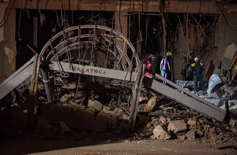 Firefighters and rescue workers remove debris from the ruins of the Saratoga Hotel. AFP