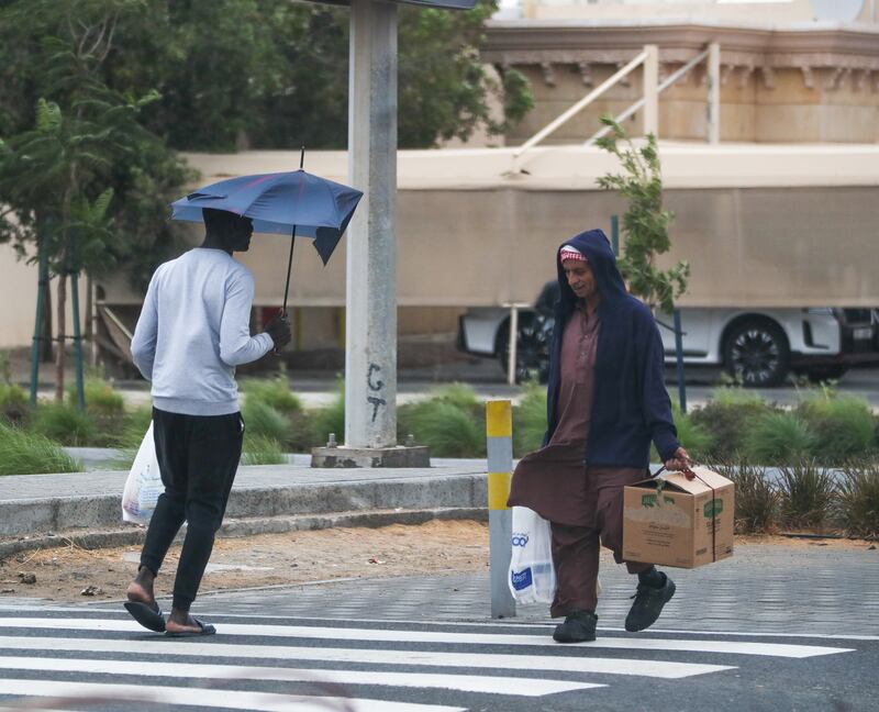 Pedestrians walk in strong winds in Khalifa City. Victor Besa / The National