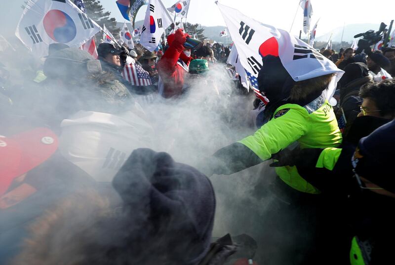 Police try to stop demonstrators from burning portraits of North Korean leader Kim Jong Un during an anti-North Korea protest before the opening ceremony for the Pyeongchang 2018 Winter Olympics. Edgar Su, Reuters