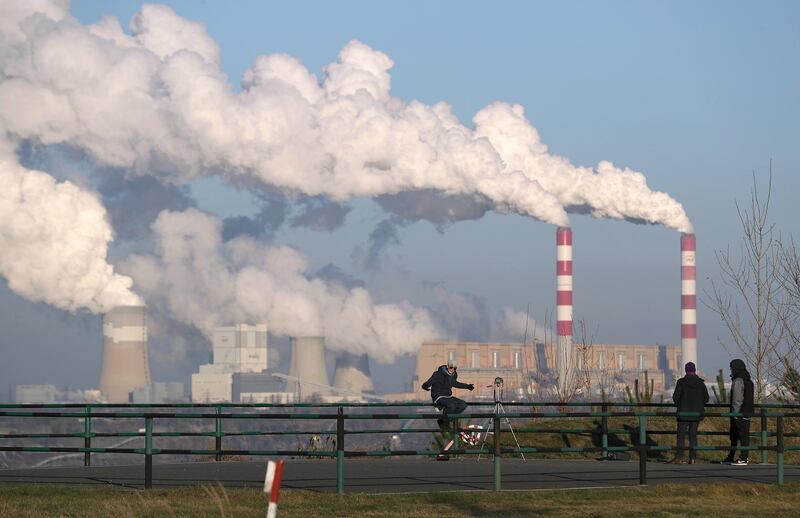 ROGOWIEC, POLAND - NOVEMBER 29: Steam and smoke rise from the Belchatow Power Station as young men film a rap music video at a viewing point over the open-pit coal mine that feeds Belchatow with coal on November 29, 2018 in Zlobnica near Rogowiec, Poland. The Belchatow station, with an output of 5,472 megawatts, is the world's largest lignite coal-fired power station. The station emits approximately 30 million tonnes of CO2 per year. The United Nations COP 24 climate conference is due to begin on December 2 in nearby Katowice, two hours south of Belchatow.  (Photo by Sean Gallup/Getty Images)