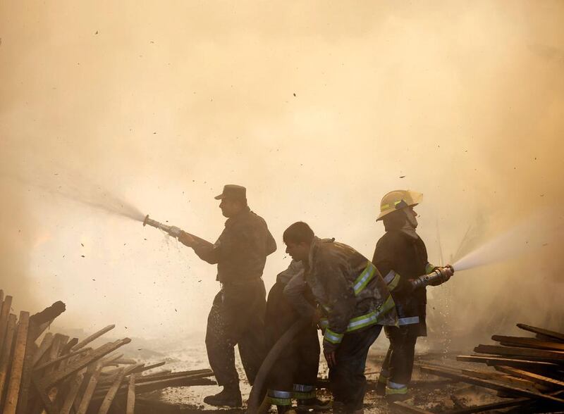 Afghan firefighters try to extinguish a fire which broke out at a wood market in Kabul, Afghanistan. Omar Sobhani / Reuters