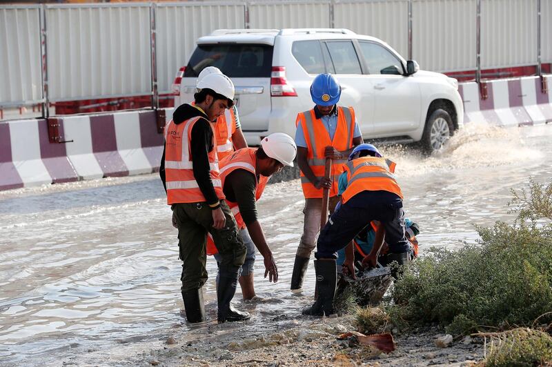 DUBAI , UNITED ARAB EMIRATES , JAN 09 – 2018 :- Workers at the under construction Dubai Metro site clearing the blocked drainage because of last night rain in Discovery Gardens area in Dubai.  (Pawan Singh / The National) For News. 