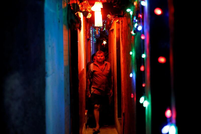 Residents walk in a slum's alley illuminated by colourful lights on the eve of the Hindu festival of Diwali in Mumbai, India,.Reuters