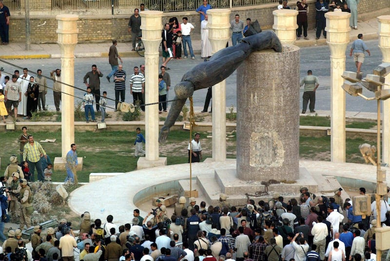 (FILES) In this file photo taken on April 9, 2003 Iraqis watch a statue of Iraqi President Saddam Hussein falling in Baghdad's al-Fardous (paradise) square.
On April 9, 2003, the US-led coalition overthrew Saddam Hussein. Fifteen years after the invasion, life in Iraq has been transformed as sectarian clashes and jihadist attacks have divided families and killed tens of thousands of people, leaving behind wounds that have yet to heal and a lagging economy. / AFP PHOTO / Patrick BAZ