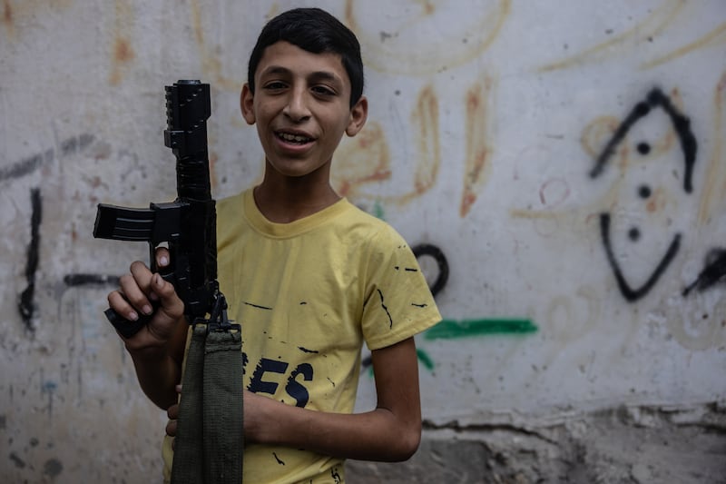 Karam, 14, with a toy gun in Nur Shams refugee camps. Karam grew up a refugee - he has never been able to leave Nur Shams camp 
