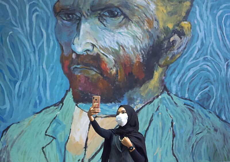 A visitor wearing a protective face mask takes a selfie near an art-wall painted by Indonesian artist Hanafi at Kertas Gallery during an exhibition in Depok, near Jakarta, Indonesia. Reuters