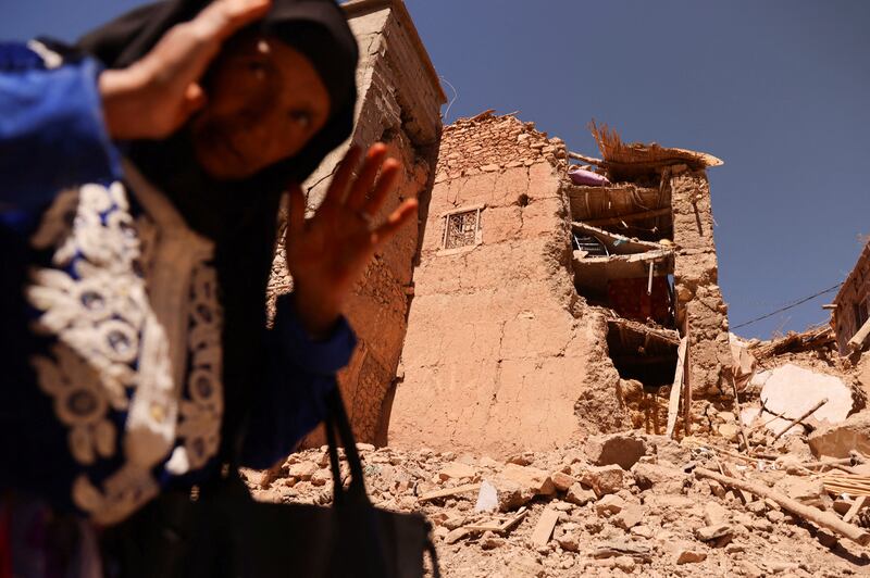 A woman gestures in front of a partly destroyed mosque in Adassil, Morocco. Reuters