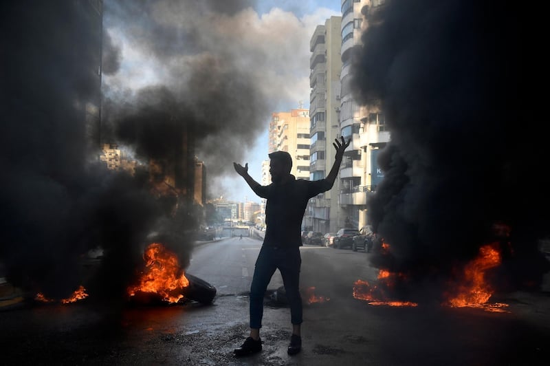 A demonstrator stands silhouetted between burning tyres, during a protest against power cuts in Beirut, Lebanon. EPA