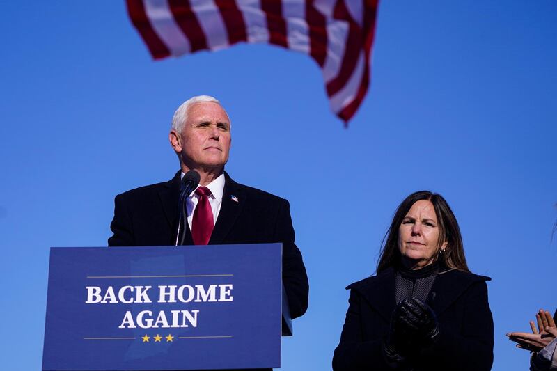 FILE - In this Jan. 20, 2021, file phot, former Vice President Mike Pence speaks after arriving back in his hometown of Columbus, Ind., as his wife Karen watches. Pence is steadily re-entering public life as he eyes a potential run for the White House in 2024. He's writing op-eds, delivering speeches, preparing trips to early voting states and launching an advocacy group likely to focus on promoting the accomplishments of the Trump administration. (AP Photo/Michael Conroy, File)