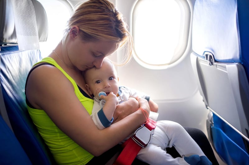 Young mother and her baby boy traveling by plane. Getty Images
