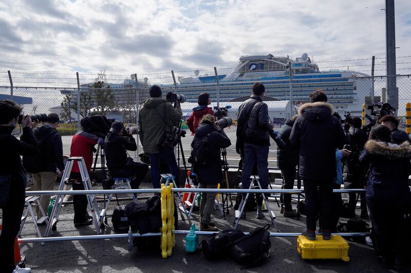 Members of the media work near the Diamond Princess cruise at the Daikoku Pier Cruise Terminal in Yokohama.  EPA