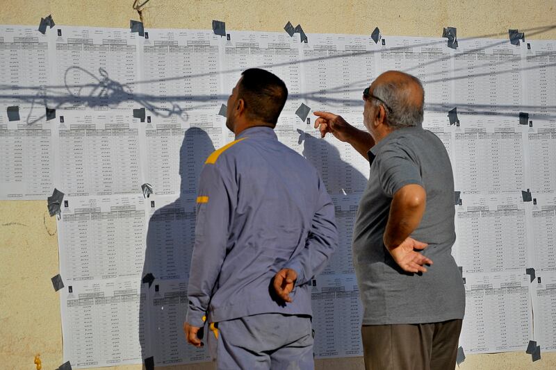 Iraqis search for their names on a list at a polling station in Najaf. Photo: AP