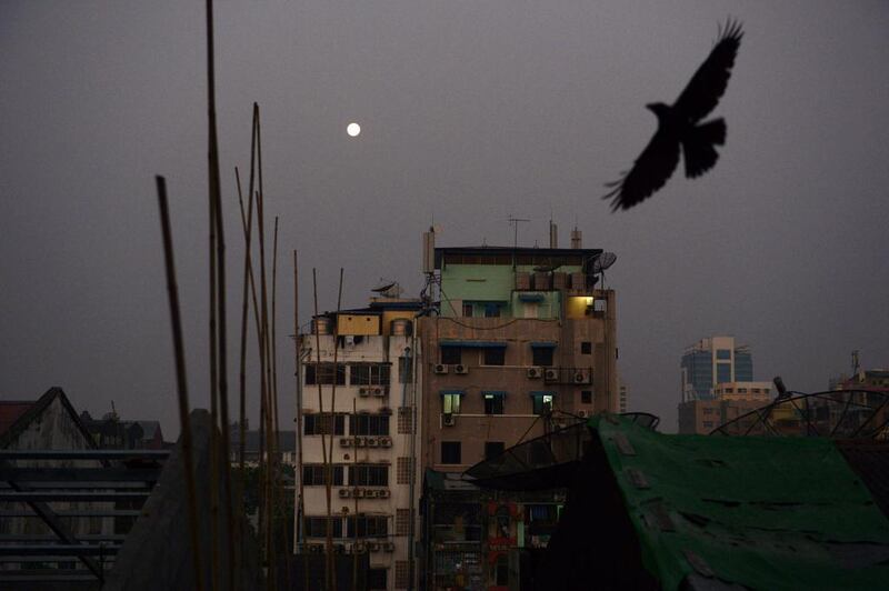A crow flies over rows of residential apartments at dawn over Yangon. Romeo Gacad / AFP Photo
