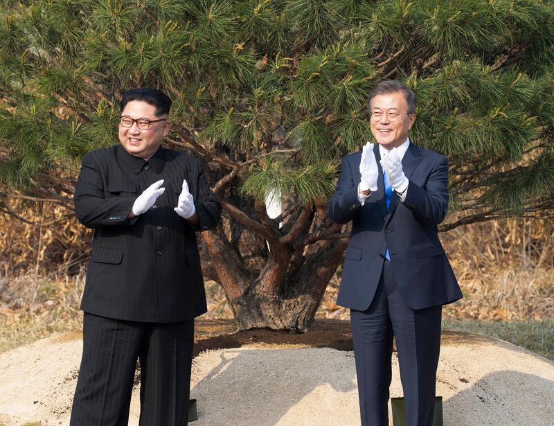 South Korean President Moon Jae-in and North Korean leader Kim Jong-un clap after planting a commemorative tree at the Joint Security Area in the border village of Panmunjom in Paju, South Korea, on April 27, 2018.