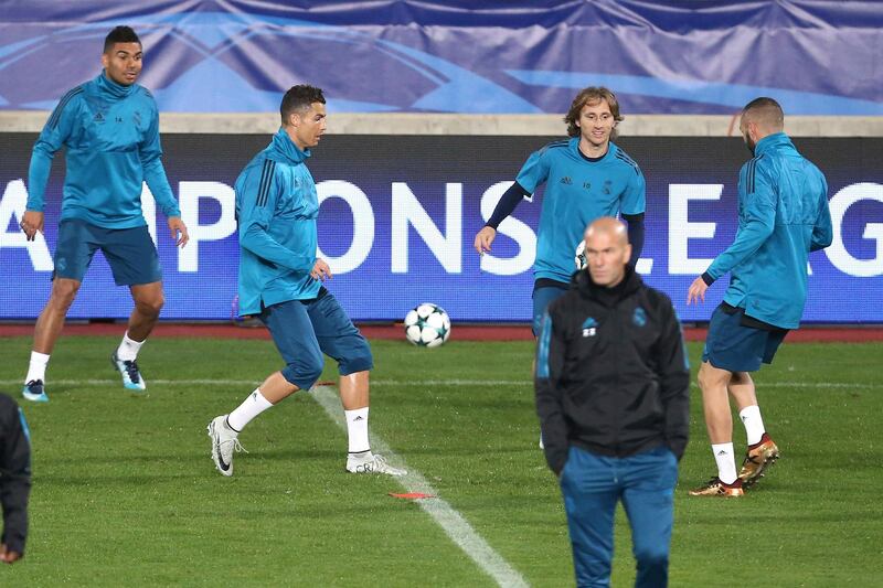 Real Madrid coach Zinedine Zidane, foreground, walks as his players warm up during a training session at GSP stadium, in Nicosia, Cyprus, on Monday, Nov. 20, 2017. Real Madrid will play against APOEL Nicosia in a Champions League Group H soccer match on Tuesday. (AP Photo/Petros Karadjias)