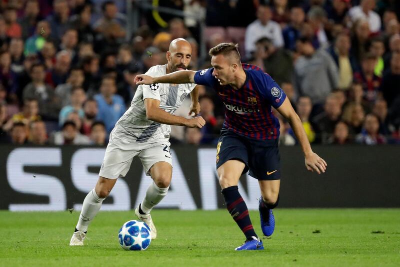 Inter midfielder Borja Valero, left, and Barcelona midfielder Arthur challenge for the ball during the Champions League, group B soccer match between Barcelona and Inter Milan, at the Nou Camp in Barcelona, Spain, Wednesday, Oct. 24, 2018. (AP Photo/Emilio Morenatti)