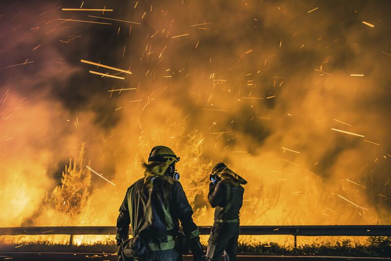 Firefighters battle the flames of a forest fire in the parish of Cures, in Boiro, north-western Spain. EPA