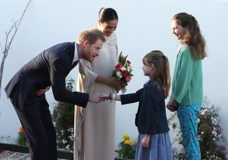 Prince Harry and Meghan are greeted by Orla Reilly, aged 12, and Elsa Reill,y aged eight, the daughters of the British ambassador to Morocco. EPA