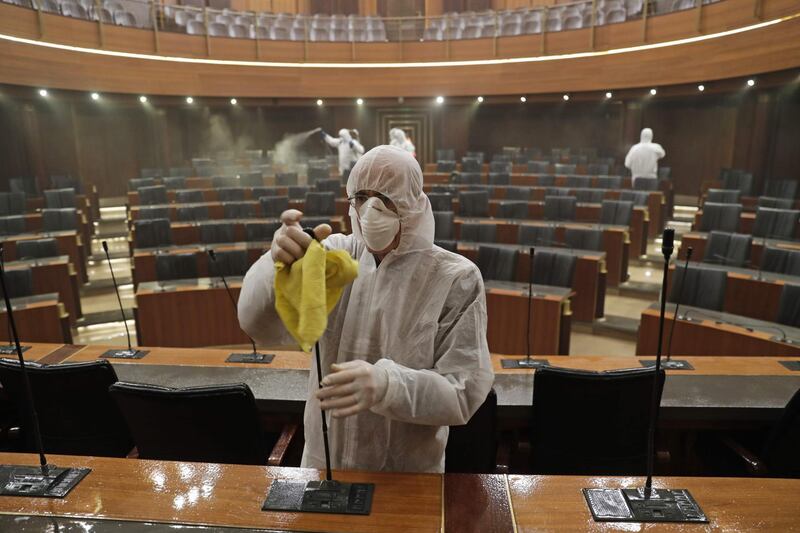 Sanitary workers disinfect the desks and chairs of the Lebanese Parliament in central Beirut. AFP