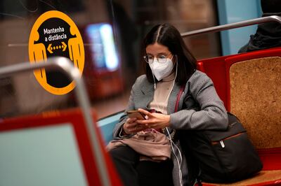 A woman wearing a face mask on a subway train in Lisbon. AP