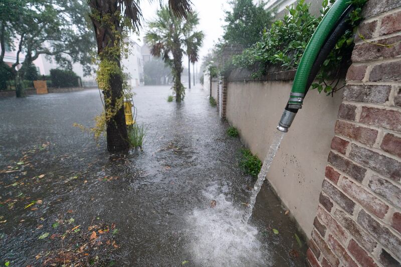 Residents use pumps to remove water from around their homes in the historic Battery as the effects from Hurricane Ian are felt in Charleston. AP