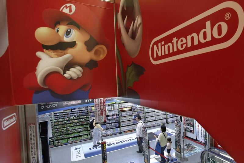 Shoppers walk under the logo of Nintendo and Super Mario characters at an electronics store in Tokyo. AP Photo/Shizuo Kambayashi