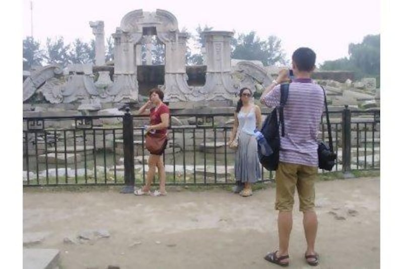 Chinese tourists pose at the Old Summer Palace in Beijing, a "patriotic education" site where Chinese learn about the damage inflicted by foreign powers.