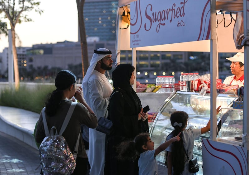 Abu Dhabi, United Arab Emirates - Emirati family purchases sweet treats at the Winter Wonderland on the Galleria Mall Waterfront. Khushnum Bhandari for The National