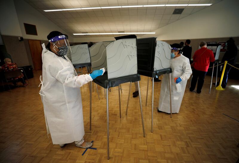 Workers sanitise voting booths for the US elections in Durham, North Carolina. Reuters