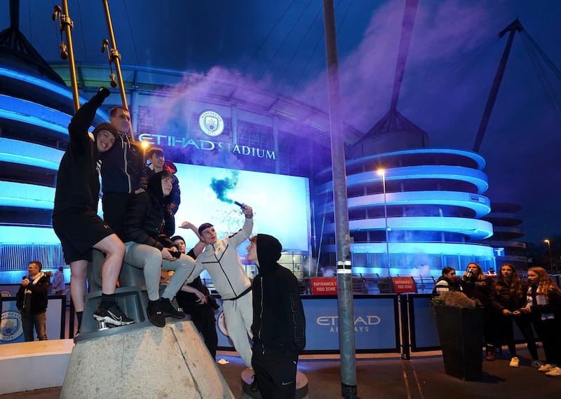 Manchester City supporters celebrate outside the Etihad Stadium. PA