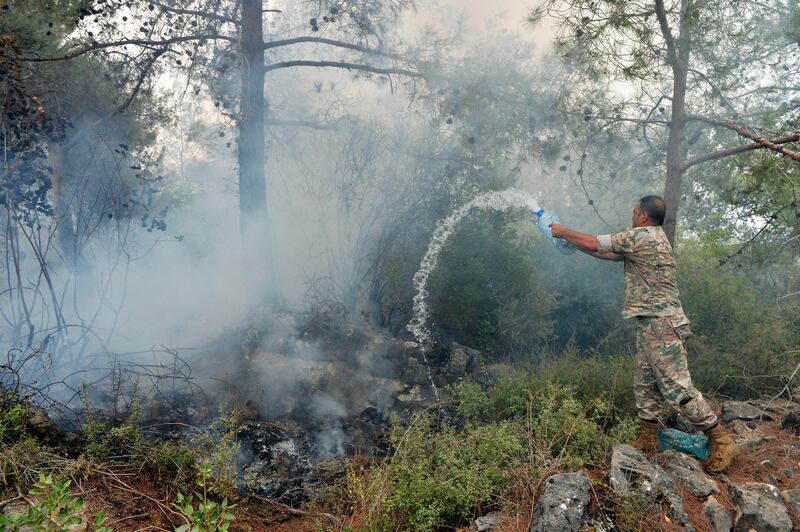 epa07922181 A Lebanese army soldier tries to extinguish a fire in Mechref area south Beirut, Lebanon, 15 October 2019. According to reports, 18 Lebanese people were admitted to hospitals for treatment following multiple wildfires that began early on 14 October in Mechref, Dibbiyeh and Al Damour areas at Chouf District in Mount Lebanon. Lebanese Army helicopters and planes provided by Cyprus were fighting the fires on 15 October morning as dozens of Civil Defense teams worked to extinguish blazes that entered residential areas. Five Civil Defense firefighters have sustained injuries during their duty.  EPA/WAEL HAMZEH