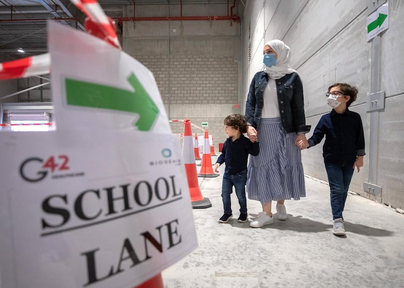 Abu Dhabi, United Arab Emirates, March 18, 2021.  A mother takes her children, Ryan Al Mulla, 6 and Omar, three years old, to get saliva tested at the Biogenix lab at G42 in Masdar City. 
Victor Besa/The National
Section:  NA
Reporter:  Shireena Al Nowais