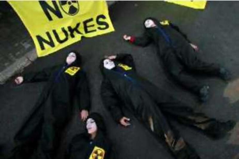 Greenpeace activists play dead in front of the Energy Ministry building in Ankara September 23, 2008. A total of 37 activists were detained by police after they protested against the Turkish government's plans to build a nuclear power station in the country. Turkish Prime Minister Tayyip Erdogan said on Monday there was no plan to postpone a tender to build and operate Turkey's first nuclear power plant, scheduled for Wednesday. Turkey has set a deadline of Sept. 24 for bids to build the plant at Akkuyu near Mersin on the Mediterranean coast with a capacity of 4,000 megawatts, plus or minus 25 percent. The stickers on the activists' overalls read, "No to nukes". REUTERS/Umit Bektas (TURKEY) *** Local Caption ***  ANK05_TURKEY-NUCLEA_0923_11.JPG