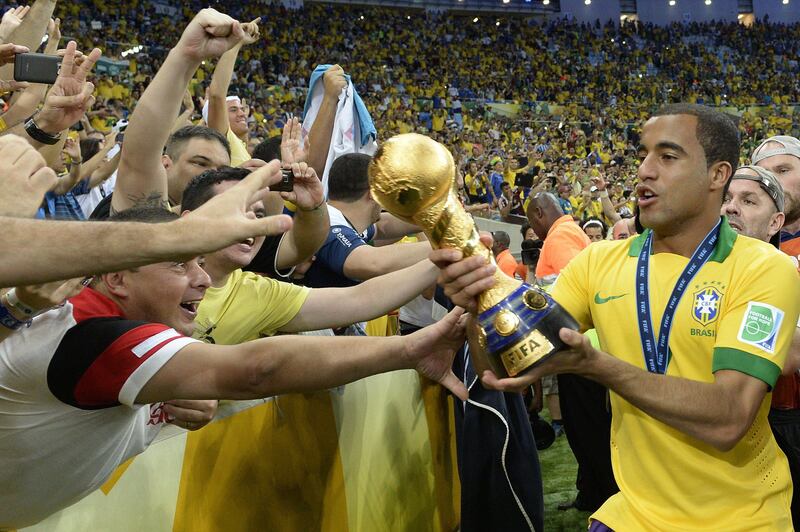 Brazil's forward Lucas (R) shows the trophy to the crowd after winning the FIFA Confederations Cup Brazil 2013 football tournament by defeating Spain 3-0 in the final, at the Maracana Stadium in Rio de Janeiro on June 30, 2013.    AFP PHOTO / JUAN BARRETO
 *** Local Caption ***  464070-01-08.jpg