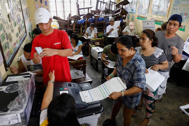 Filipinos cast their votes at an elementary school turned into a voting precinct in Quezon City, east of Manila, Philippines. .  EPA