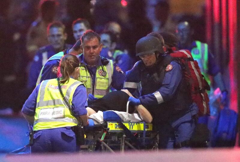 Emergency personnel wheel an injured hostage to an ambulance during a cafe siege in the central business district of Sydney, Australia on December 16, 2014.  AP Photo/Rob Griffith