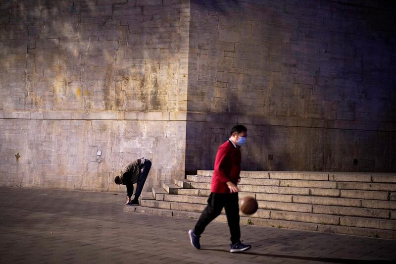 People wearing face masks exercise on a street in Wuhan, Hubei province. Reuters