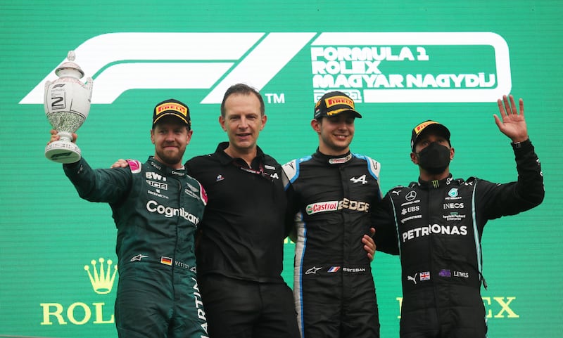 Second placed Sebastian Vettel of Aston Martin, first placed Esteban Ocon of Alpine and third placed Lewis Hamilton of Mercedes on the podium after the race.