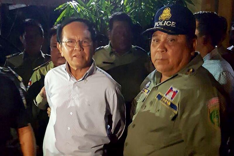 Cambodian opposition leader Kem Sokha (L) is escorted by police at his home in Phnom Penh on September 3, 2017.
Cambodian opposition leader Kem Sokha was arrested early on September 3 accused of treason, the government said in a statement, the latest in a flurry of legal cases lodged against critics and rivals of strongman premier Hun Sen. / AFP PHOTO / STR