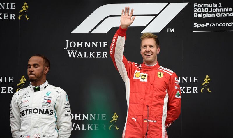 Winner Ferrari's German driver Sebastian Vettel celebrates on the podium next to second placed Mercedes' British driver Lewis Hamilton after the Belgian Formula One Grand Prix at the Spa-Francorchamps circuit in Spa on August 26, 2018. (Photo by JOHN THYS / AFP)