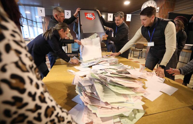 Members of a local electoral commission count ballots at a Vilnius polling station during the first round of Lithuania's presidential election. AFP