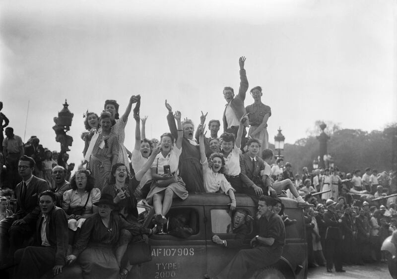 (FILES) In this file photograph taken on August 26, 1944, a cheering crowd salutes as they wait for soldiers of the Allied troops and the French 2nd armored division (2ème DB) on the Place de la Concorde in Paris, during the parade to celebrate the Liberation of Paris, during WWII. In August 1944, without waiting for the Allies to arrive, Paris rose up after four years of German occupation. On the 25th, after a week of strikes, barricades and street battles, the capital welcomed de Gaulle, who finally proclaimed "Paris liberated". / AFP / -
