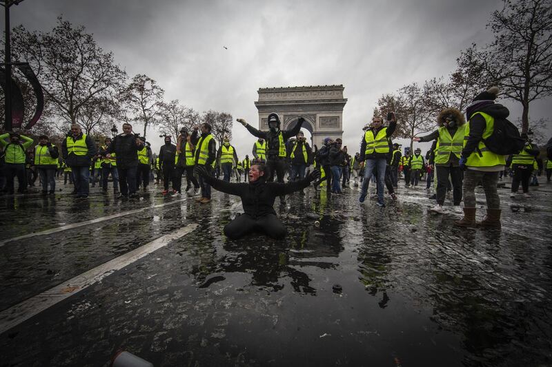 A protester is wounded by a water canon as they clash with riot police near the Arc de Triomphe in Paris. Getty Images