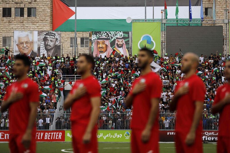 The Palestinian national football team stand for their national anthem during a World Cup 2022 Asian qualifying match between Palestine and Saudi Arabia in the Israeli occupied West Bank town of al-Ram. Portraits of Saudi King Salman, Saudi Crown Prince Mohamed bin Salman, late Palestinian leader Yasser Arafat and current Palestinian leader Mahmud Abbas. The game would mark a change in policy for Saudi Arabia, which has previously played matches against Palestine in third countries. Arab clubs and national teams have historically refused to play in the West Bank, where the Palestinian national team plays, as it required them to apply for Israeli entry permits. AFP