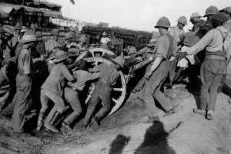 British and Indian Army soldiers shifting a field gun over a 'bund'. The Indian Expeditionary Force advanced along the River Tigris towards Baghdad during Summer 1915. Part of the expedition, 6th Poona Div., later came to grief at the siege of Kut-Al-Amara in April 1916.