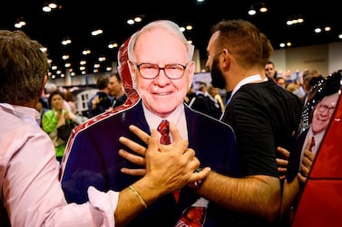 Shareholders pose with a stand-up illustration of Warren Buffett, chief executive of Berkshire Hathaway, during the recent annual shareholders meeting in Omaha, Nebraska, AFP